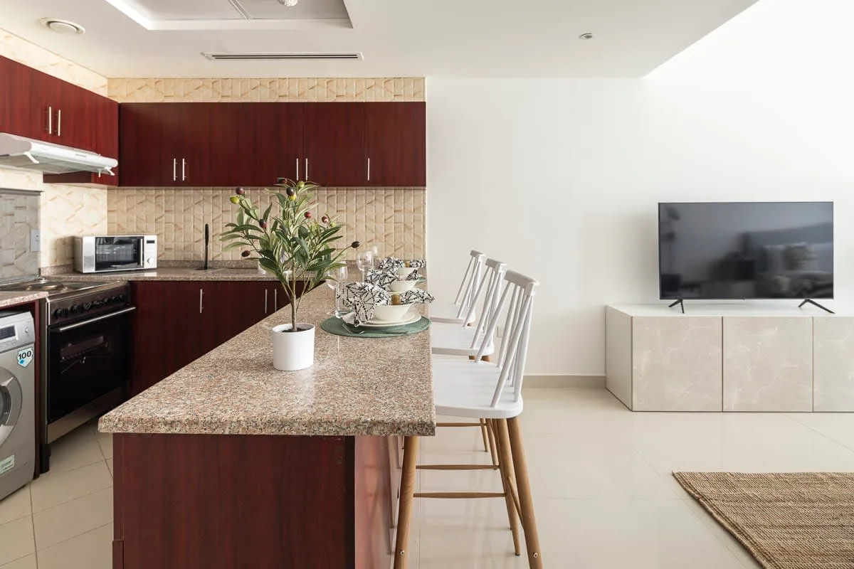 Una cocina y comedor modernos con un televisor sobre un mueble bajo.