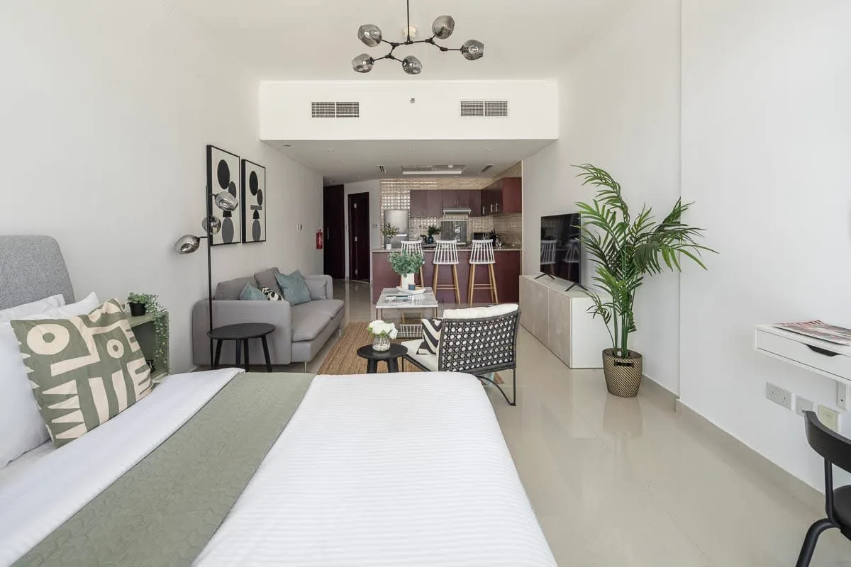 Un dormitorio luminoso con sala de estar da a una barra de comedor y cocina.
