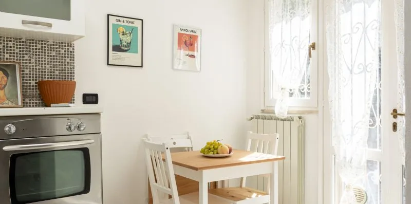 A bright kitchen and dining area with a table beside the window.