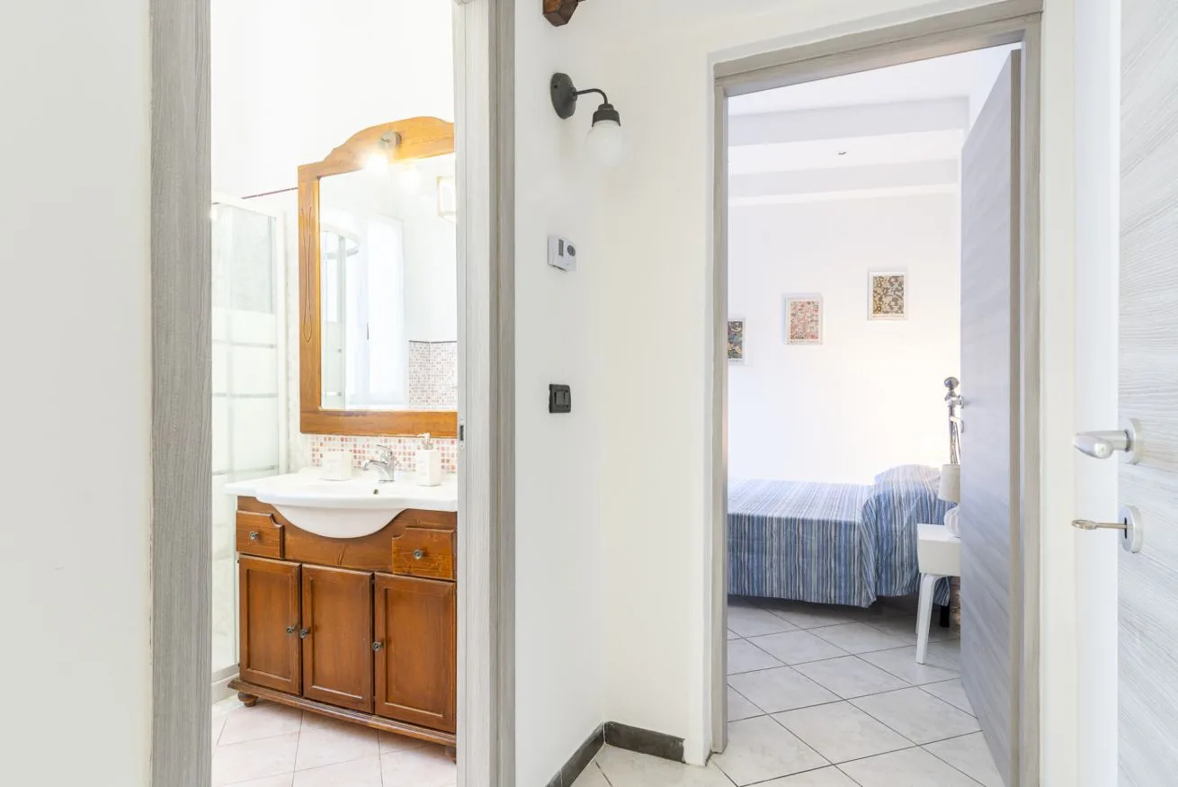 An interior doorway shows a bedroom and an adjoining bathroom vanity.