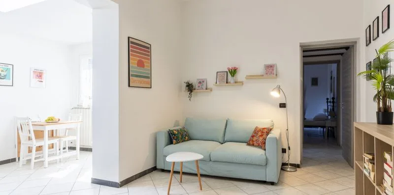 A living room with a pale blue sofa and a small round table.