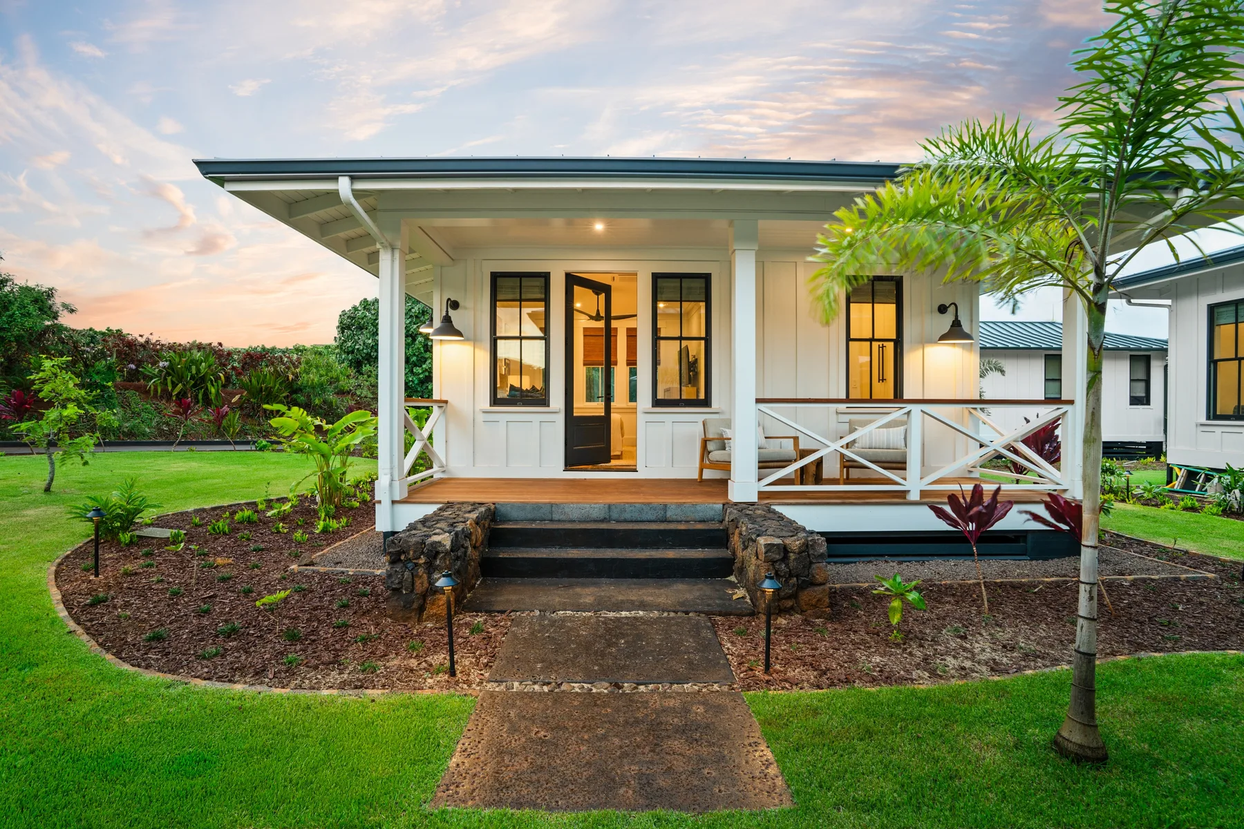 A small house with a covered porch and a path across the lawn.