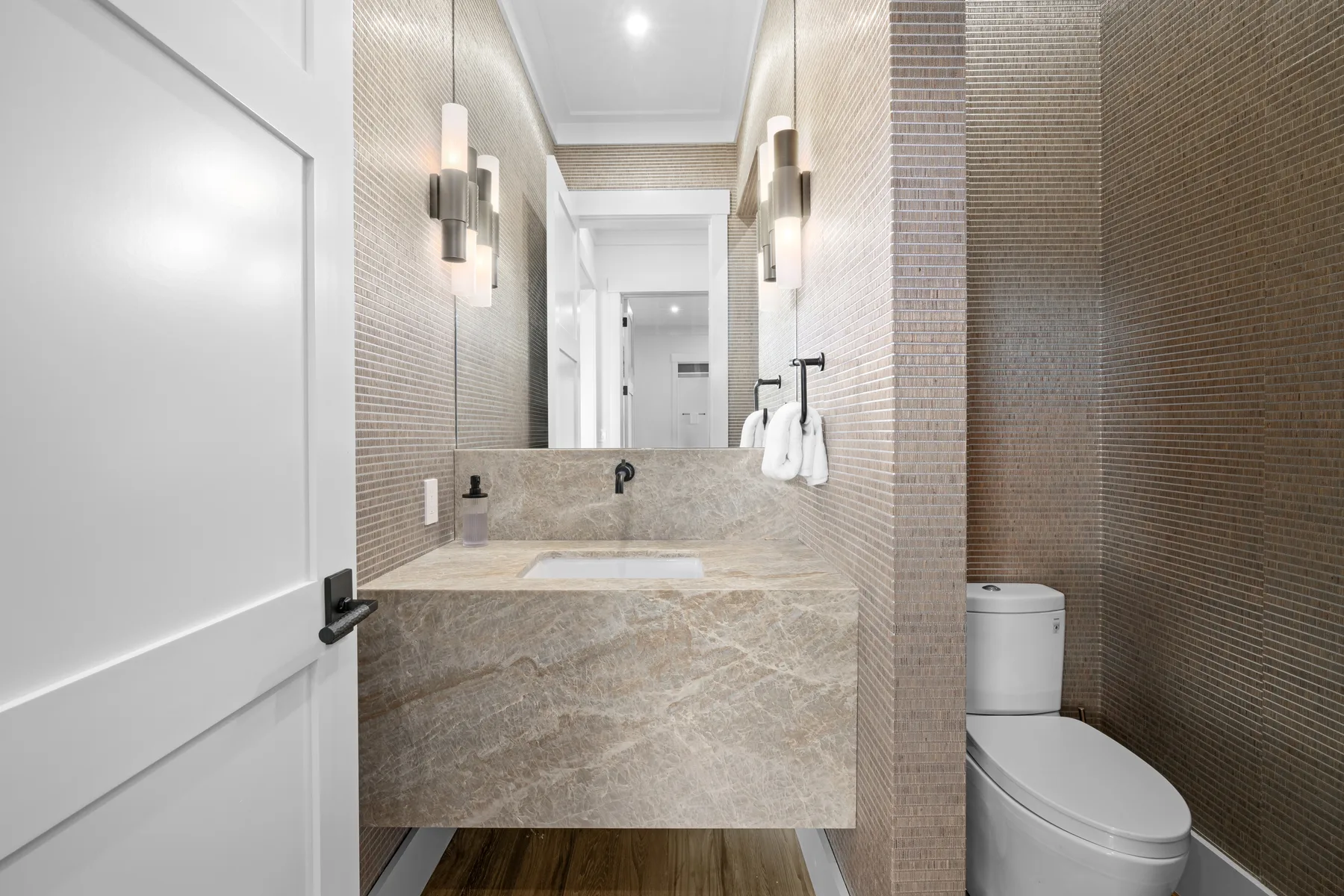 A modern bathroom with a sink, mirror, and toilet.