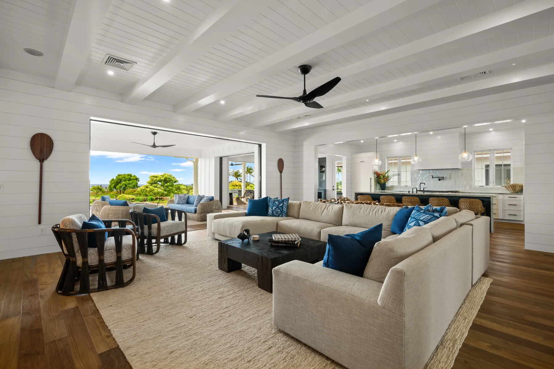 A spacious living room with a sectional seating area and an open kitchen.