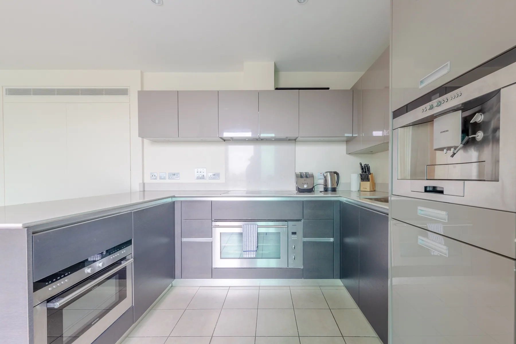 Una cocina moderna con electrodomésticos integrados y gabinetes claros.