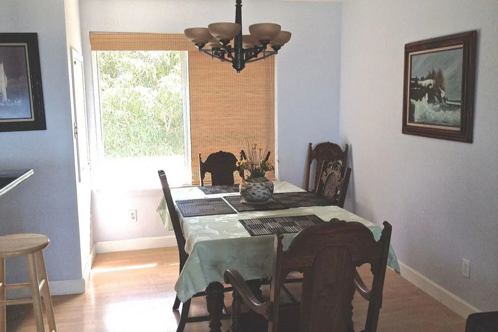 Un comedor con una mesa rectangular junto a una ventana.