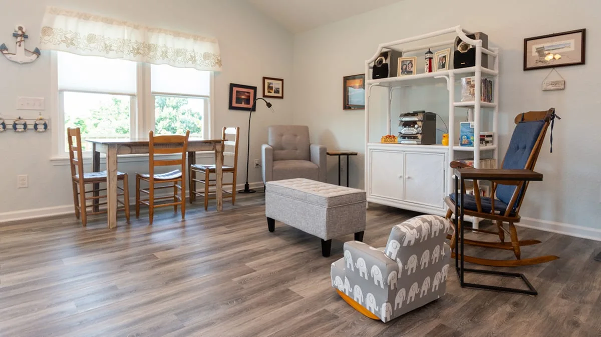 Una luminosa sala con comedor, mesa, asientos y un mueble blanco.