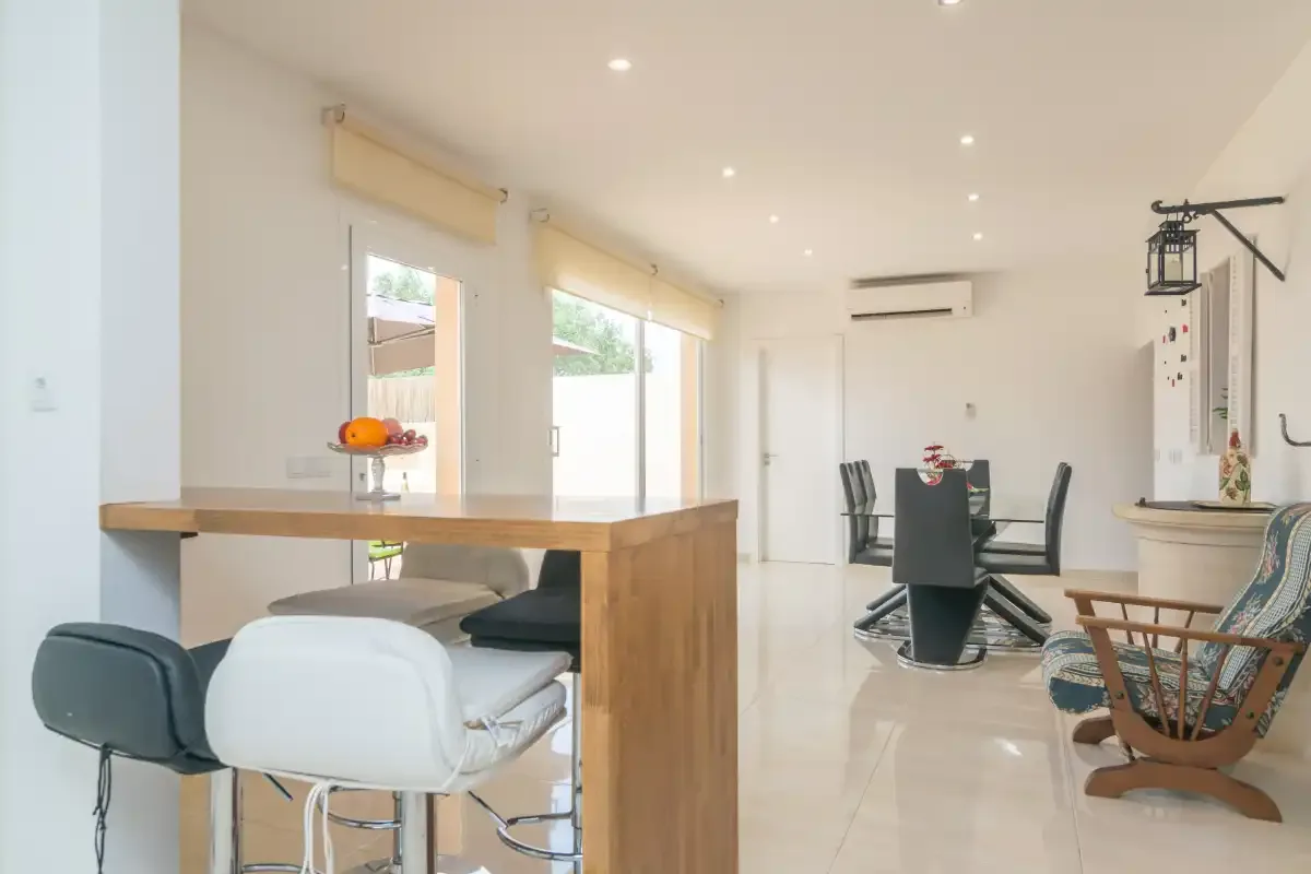 A bright open-plan dining area with a kitchen counter and table.