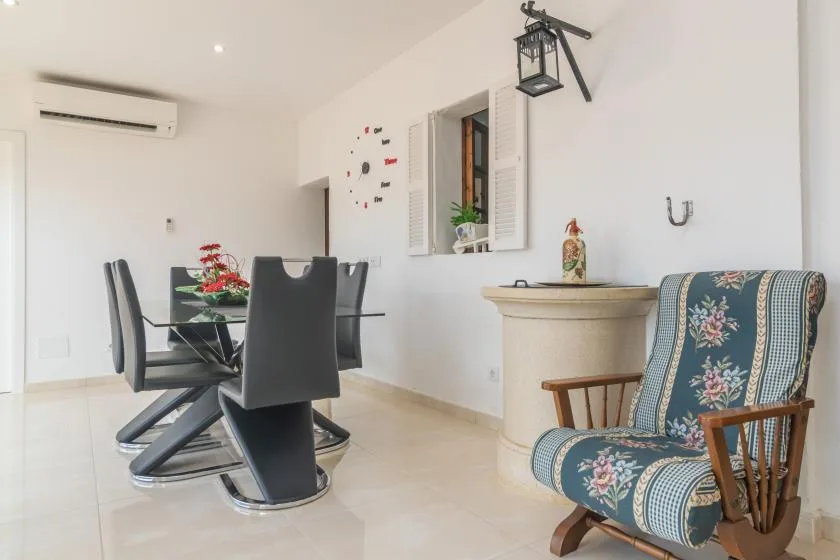 A bright dining area with a glass table and upholstered seating.