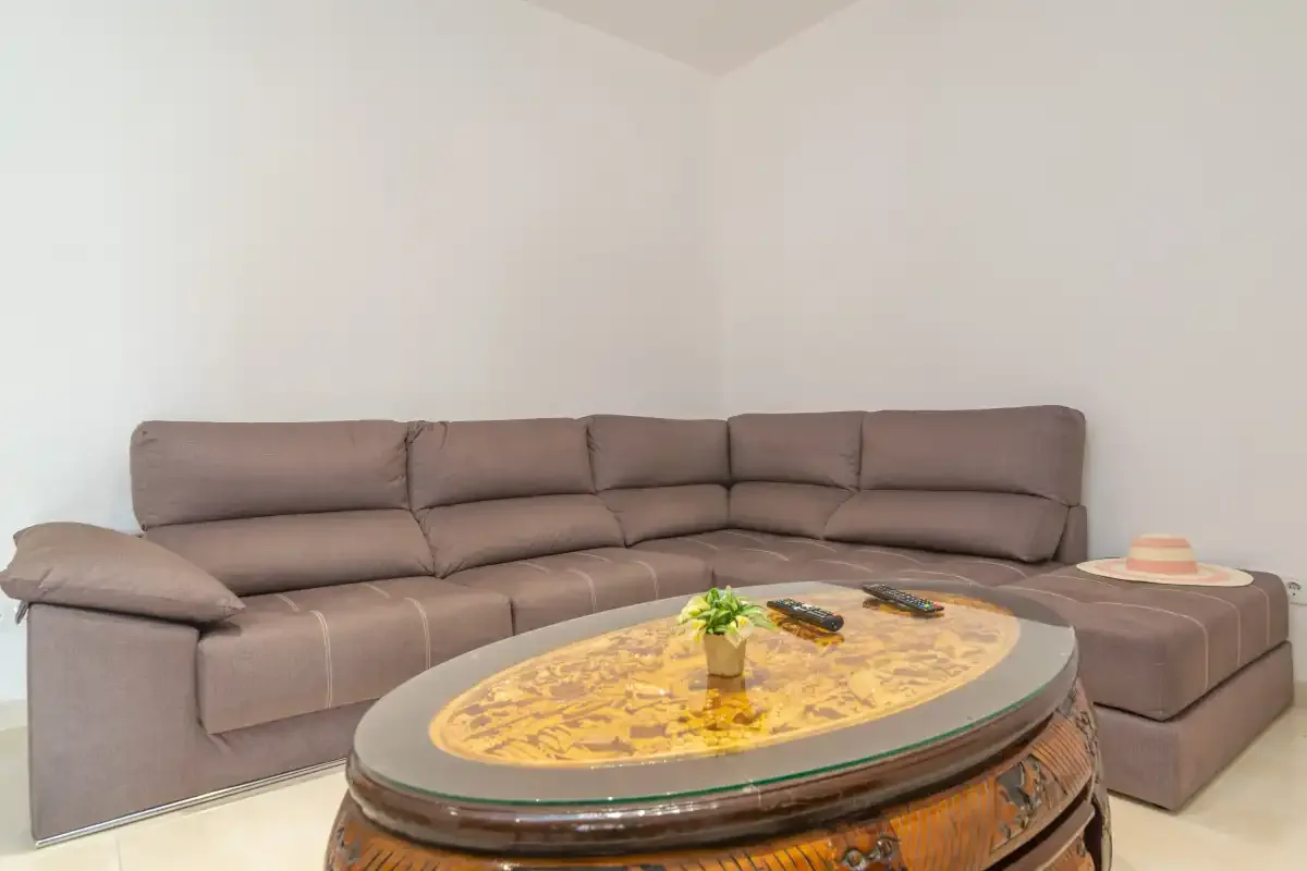 A living room with a sectional sofa and an oval coffee table.