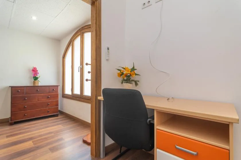 A small desk area with a chair and wooden storage furniture.