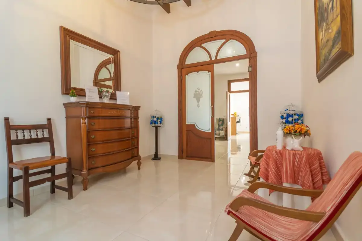 An interior sitting area with wooden furniture and an arched doorway.