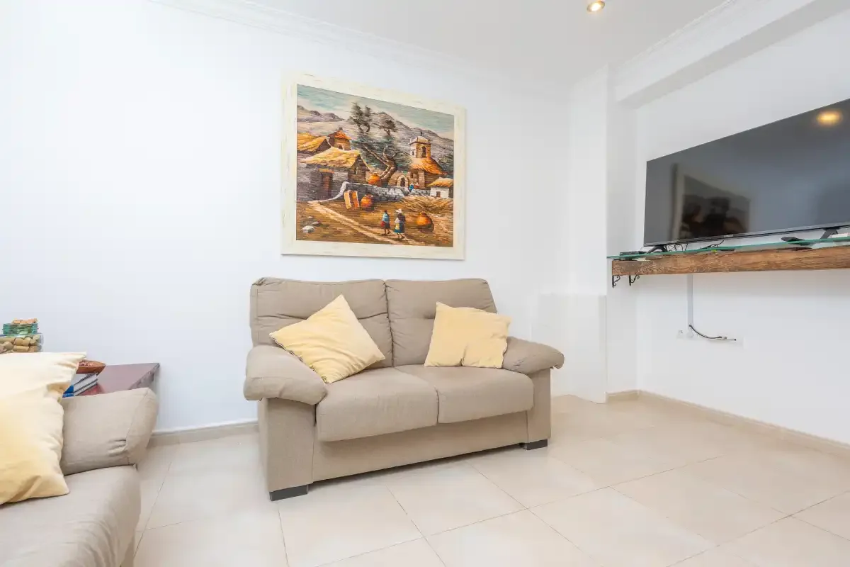 Una sala luminosa con asientos beige y un cuadro enmarcado.