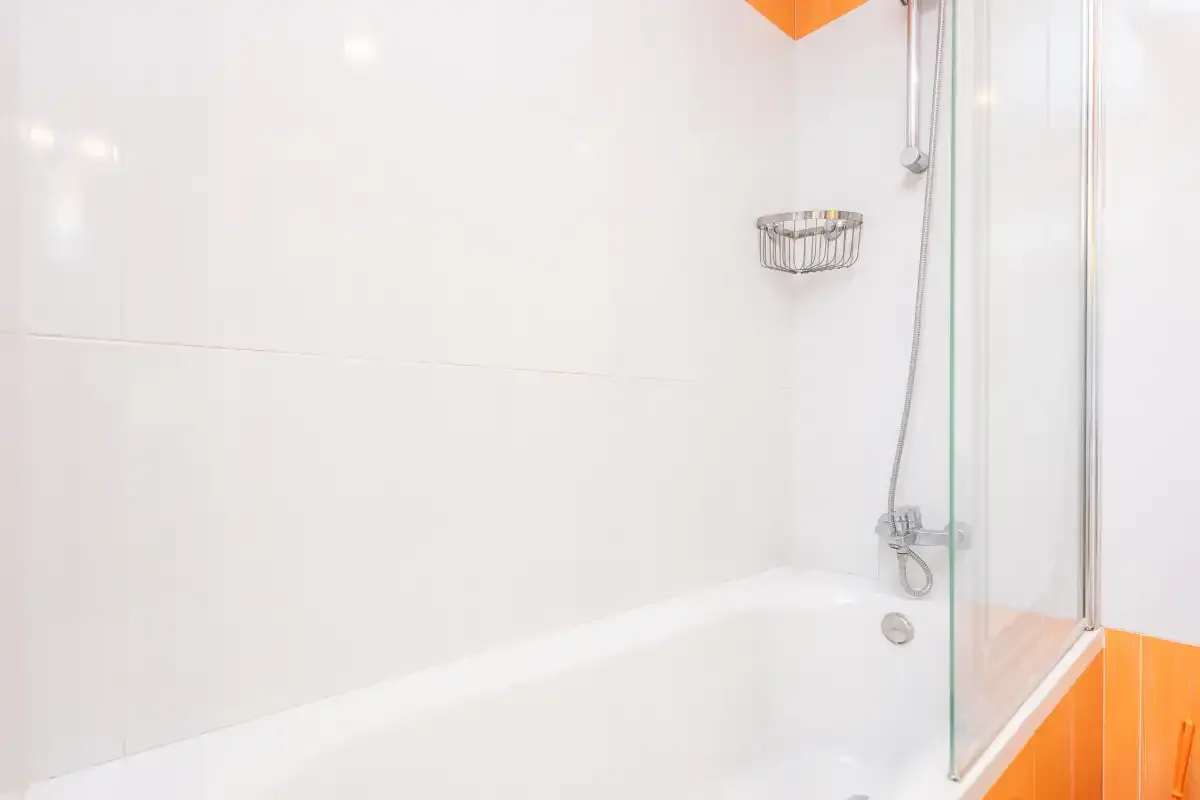 Un baño luminoso con bañera y ducha de mano.