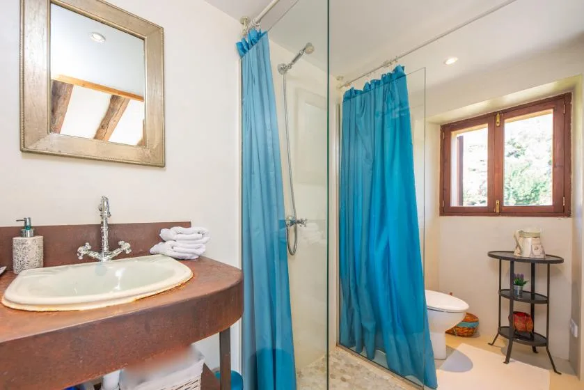 A bathroom with a sink, shower curtain, and window.