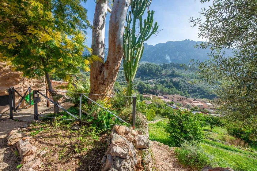 A landscaped garden overlooks a valley with homes and distant mountains.
