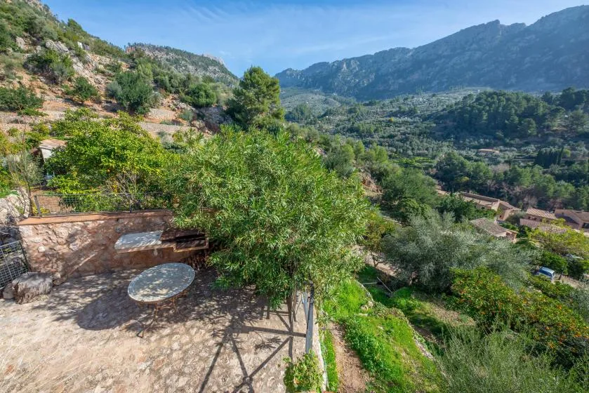 A stone patio overlooks a green mountain valley.