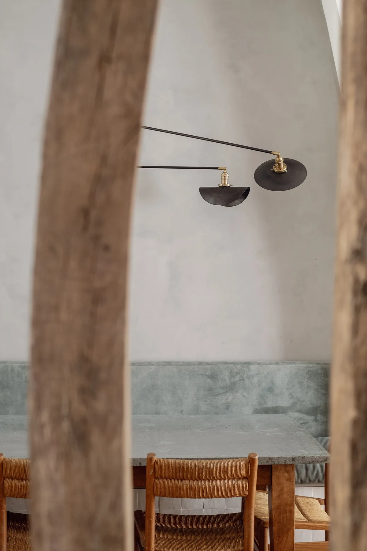 A dining area with wooden seating and two wall-mounted lights.