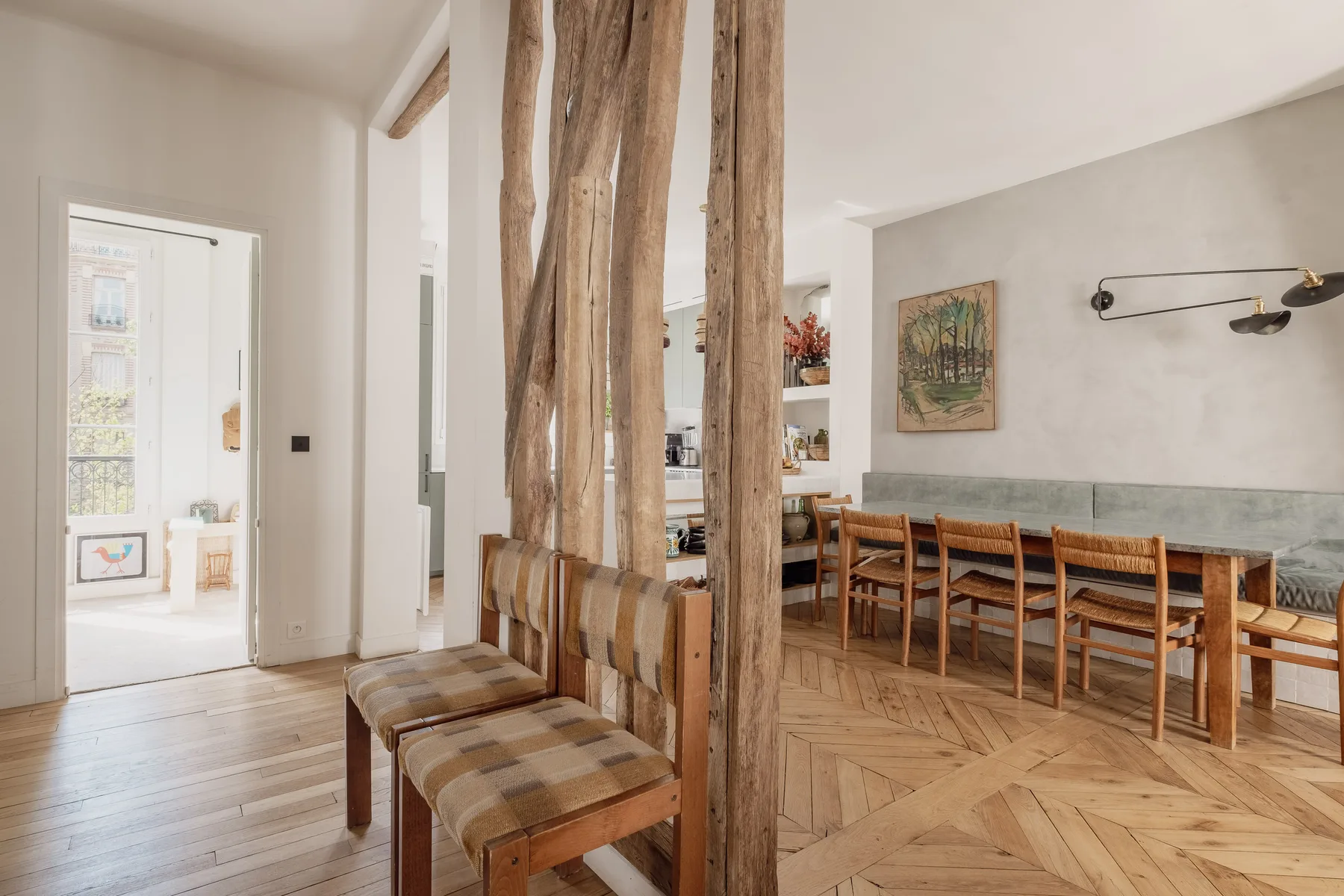 A dining area with a long wooden table and chairs beside rustic wooden posts.