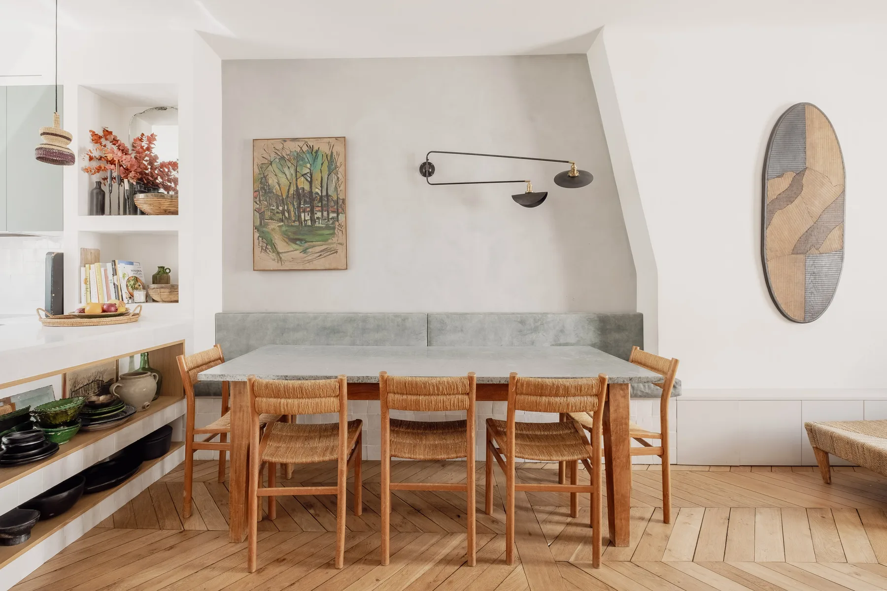 A dining area with a wooden table and chairs beside built-in seating.