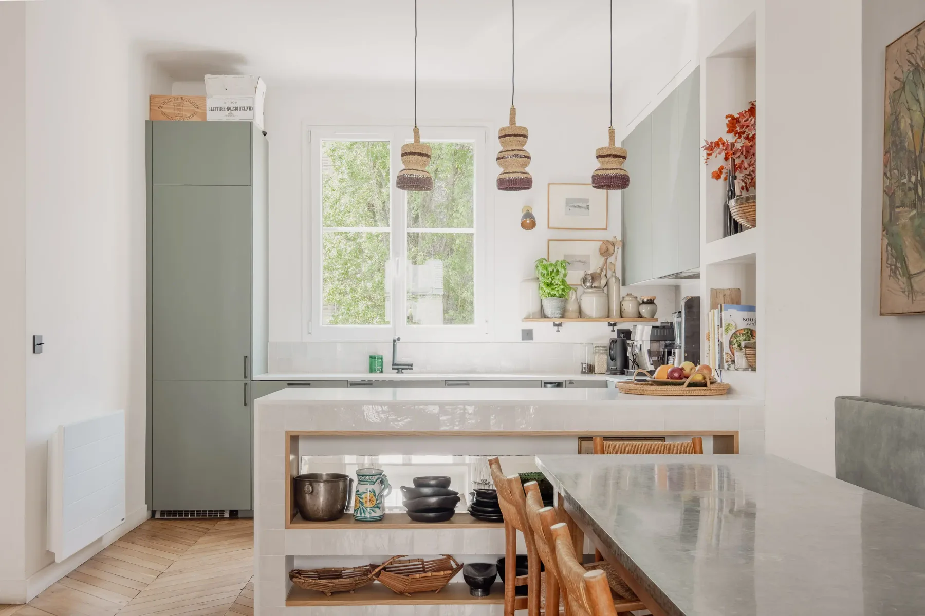 A bright kitchen with a long island and pendant lights.