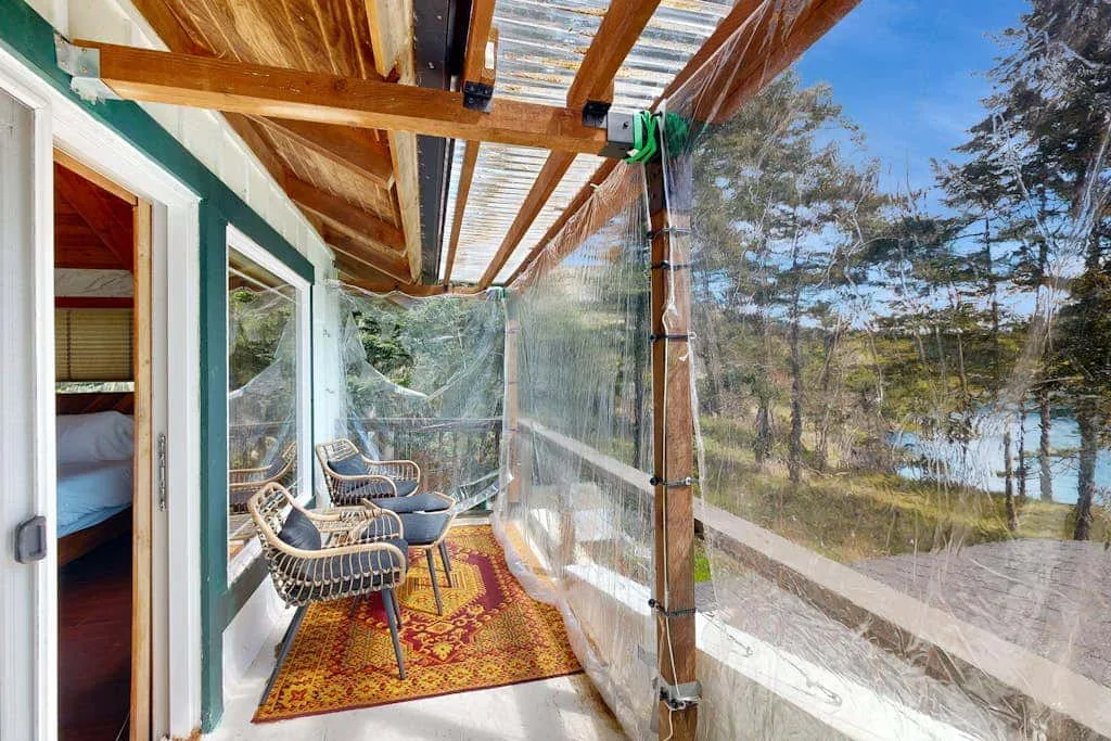 A covered outdoor seating area overlooks trees and water.