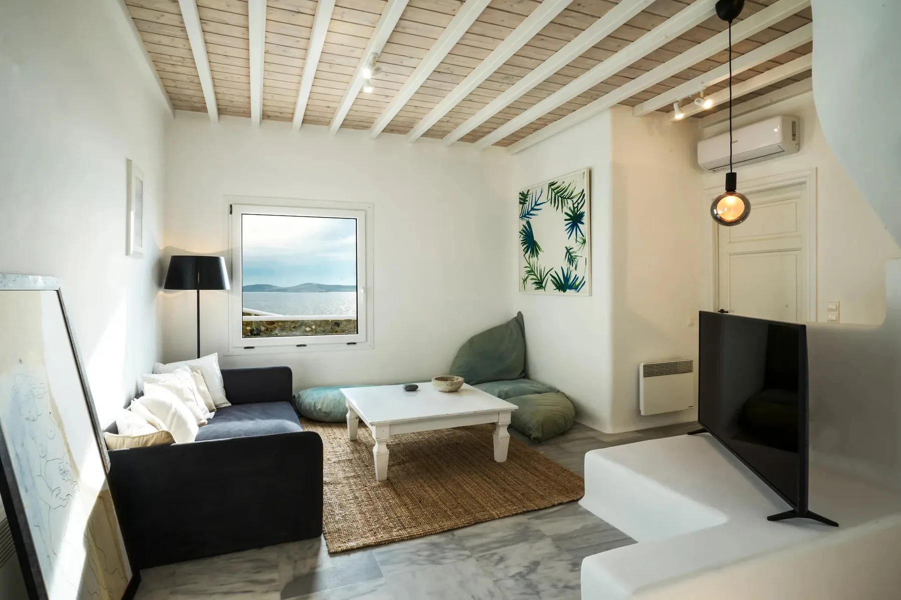 A living room with seating around a low table and a television.