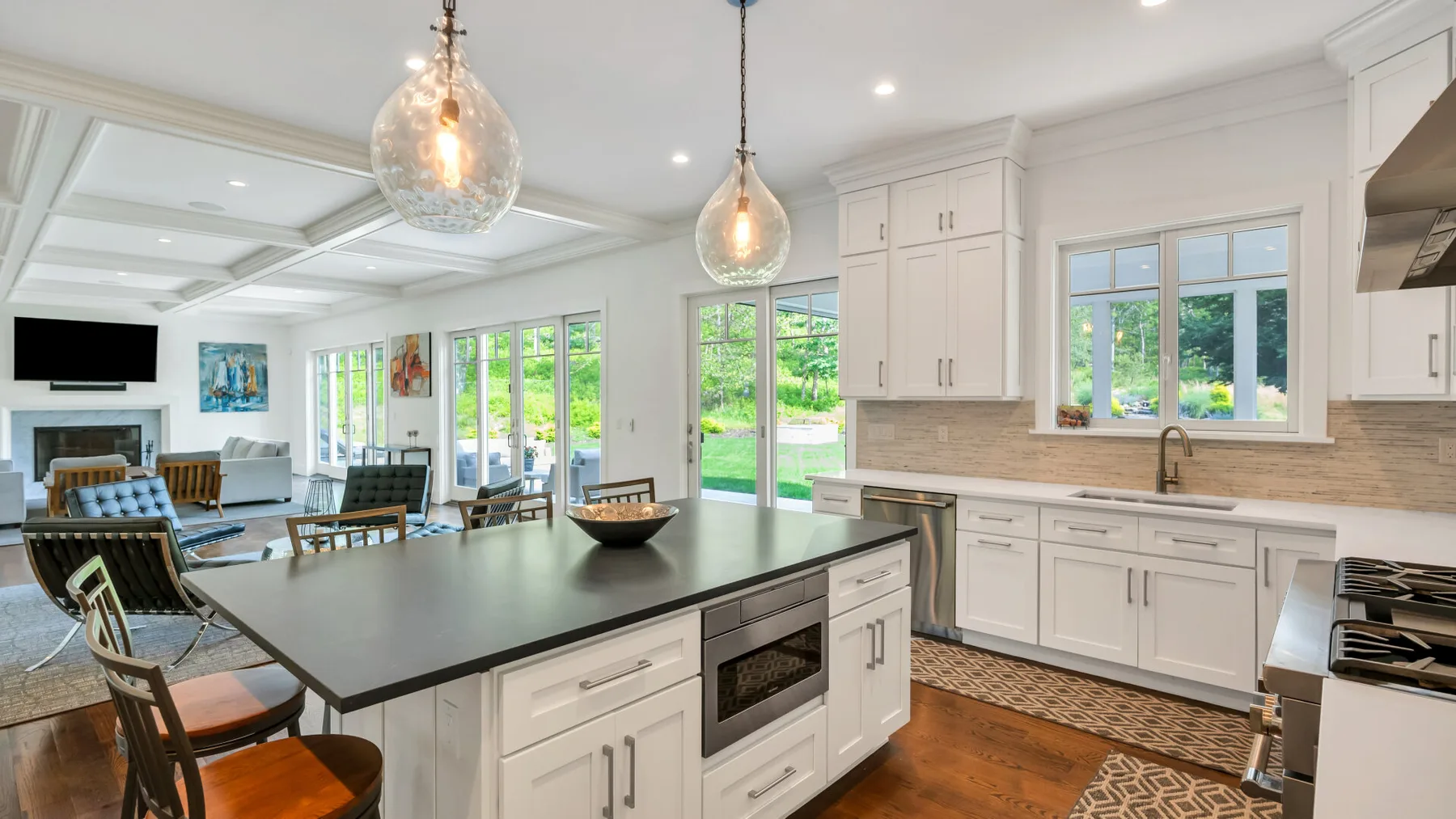 An open-plan kitchen and dining area with white cabinetry and a large island.