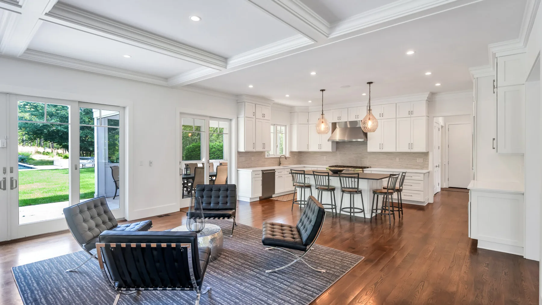 A bright open-plan living and kitchen area with a dining table and seating.