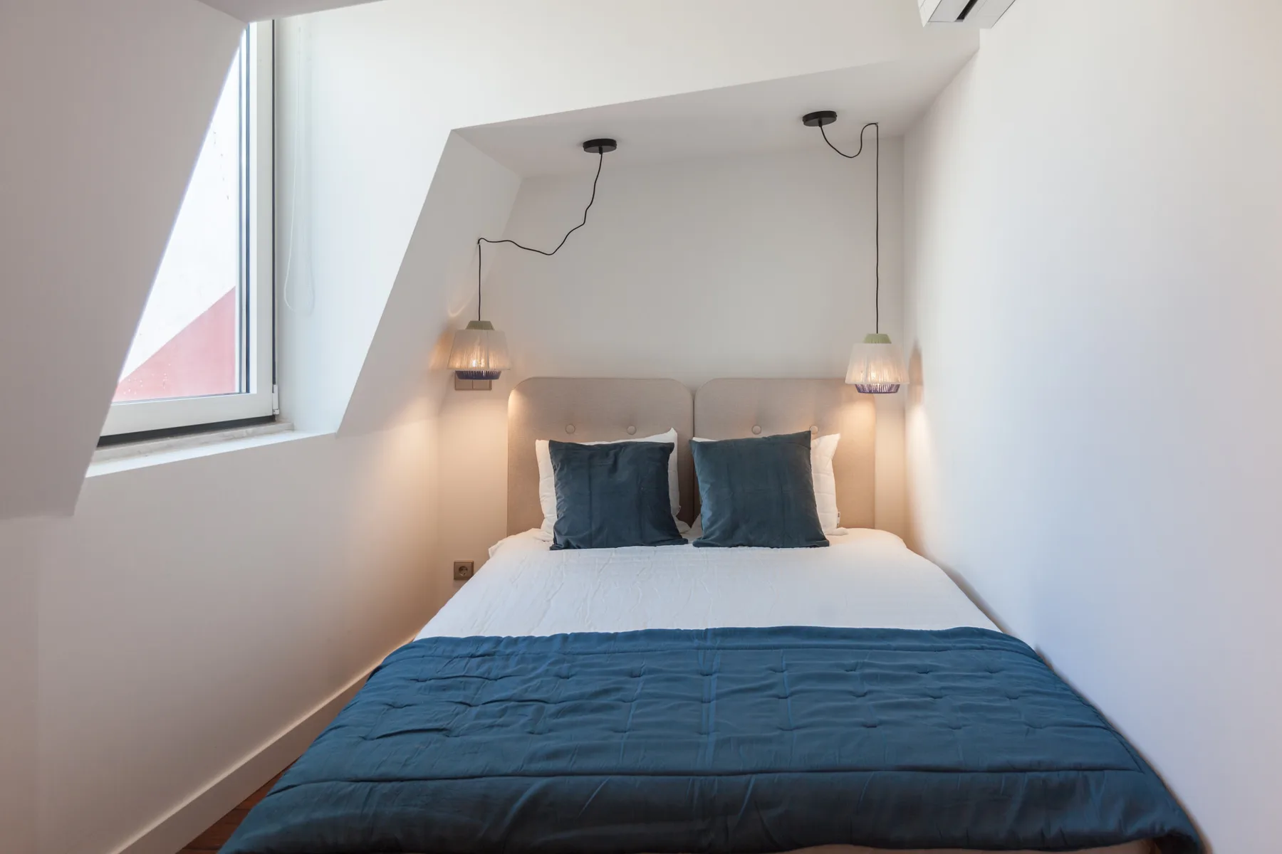 A bedroom with a bed dressed in white and blue bedding.