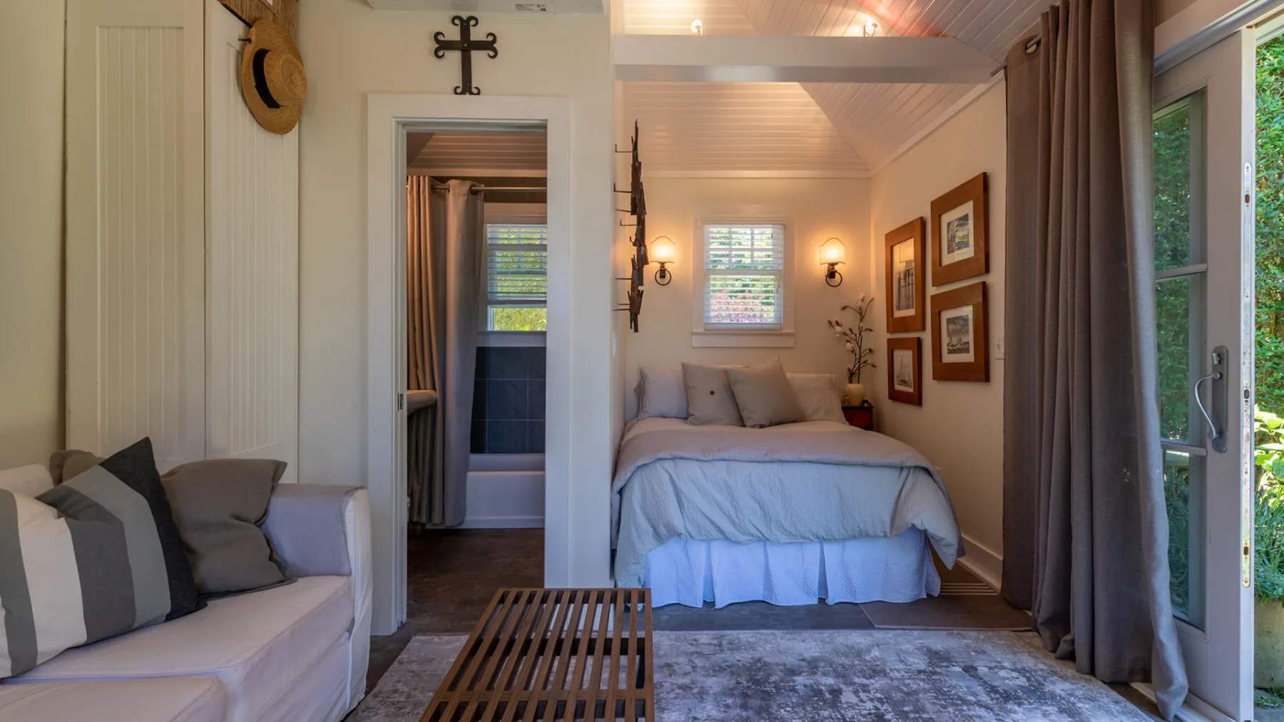 A bedroom with a bed, seating, and a large window.