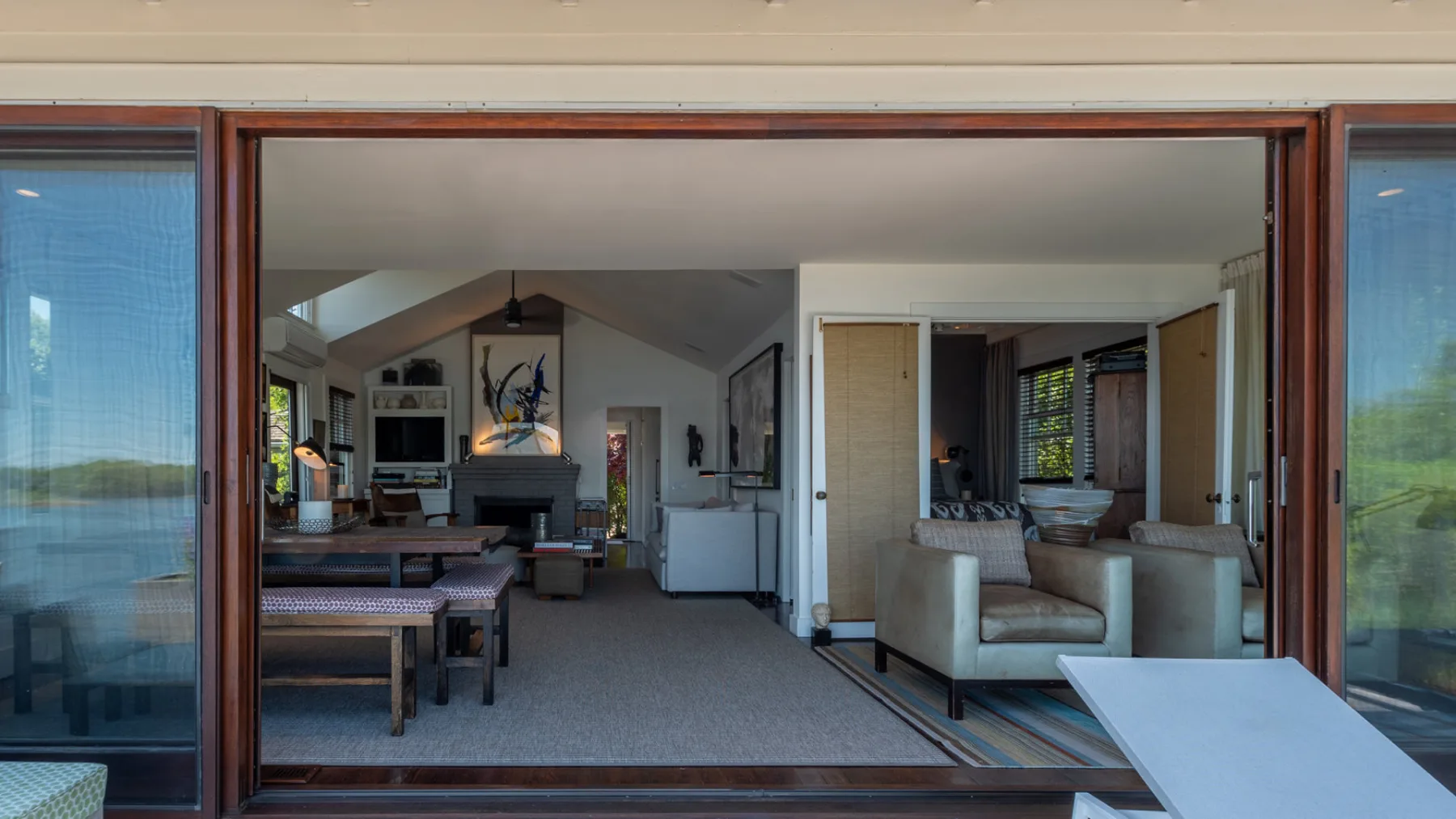 A living room and dining area open onto a view of the water.