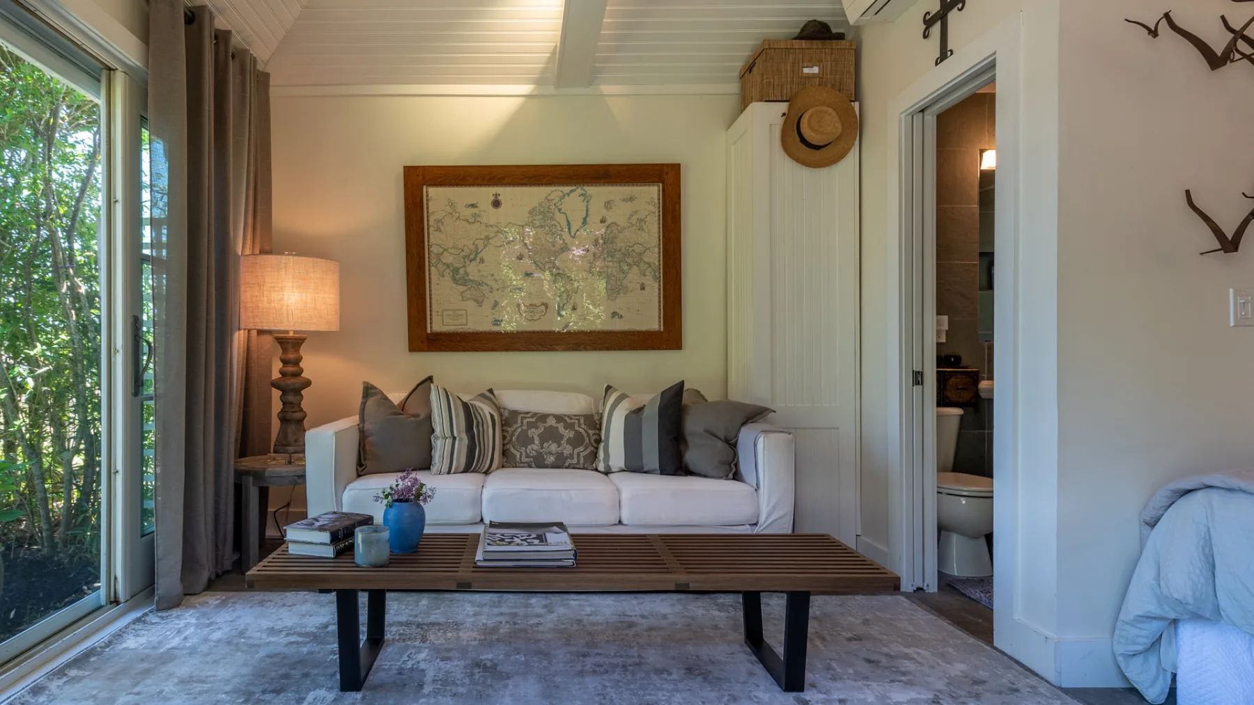 A bright sitting room with a sofa, coffee table, and framed wall art.