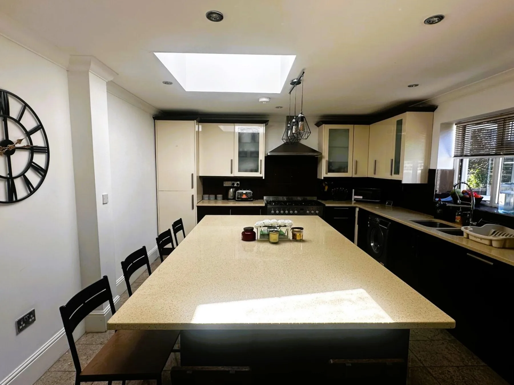 Una cocina moderna con una gran isla central y encimeras oscuras.