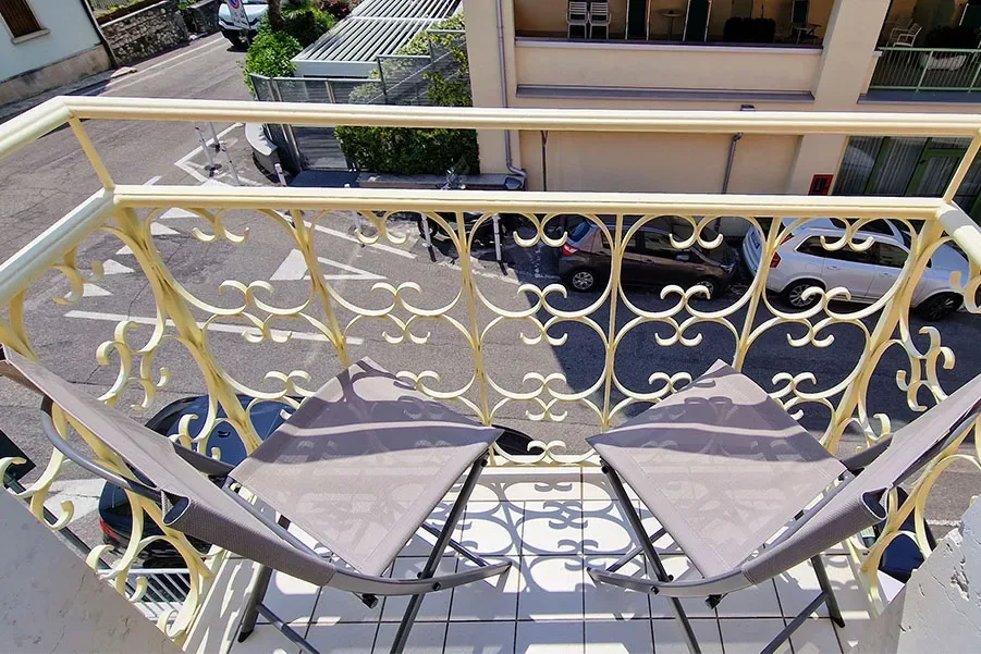 Small balcony with two folding chairs above the street