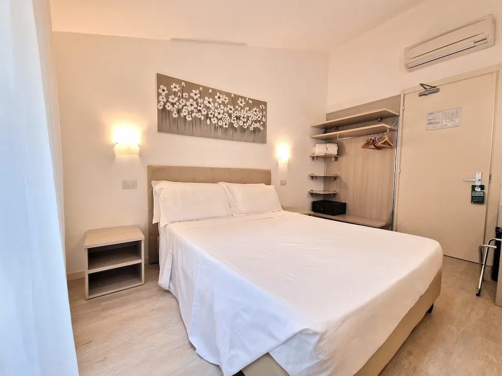 Double room with bed and open wardrobe