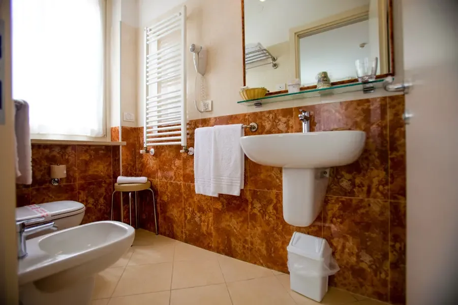 Bathroom with brown tiles and white fixtures
