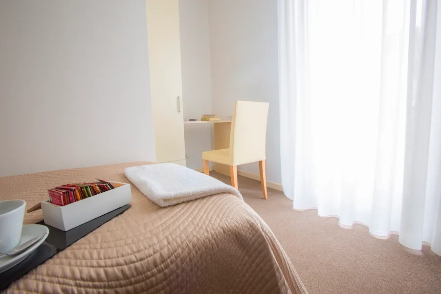 Dormitorio individual luminoso con escritorio y silla