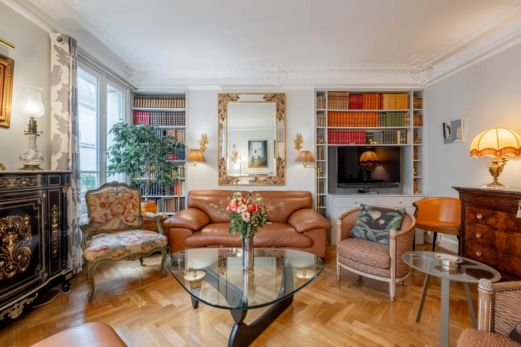 A living room with seating arranged around a glass coffee table.