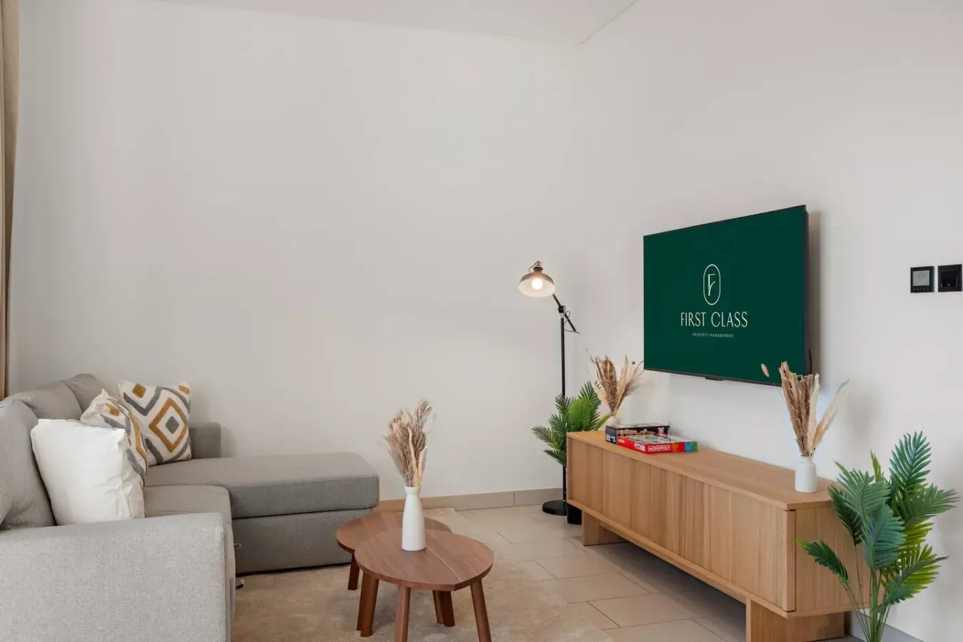 Sala de estar con asientos, una mesa de centro y un televisor sobre un mueble de madera.