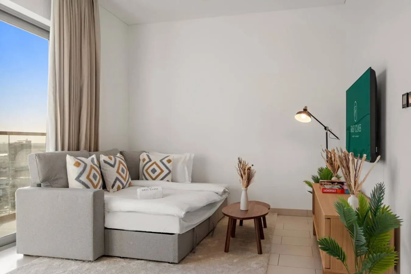 Una sala luminosa con sofá seccional, mesa de centro y una ventana grande.