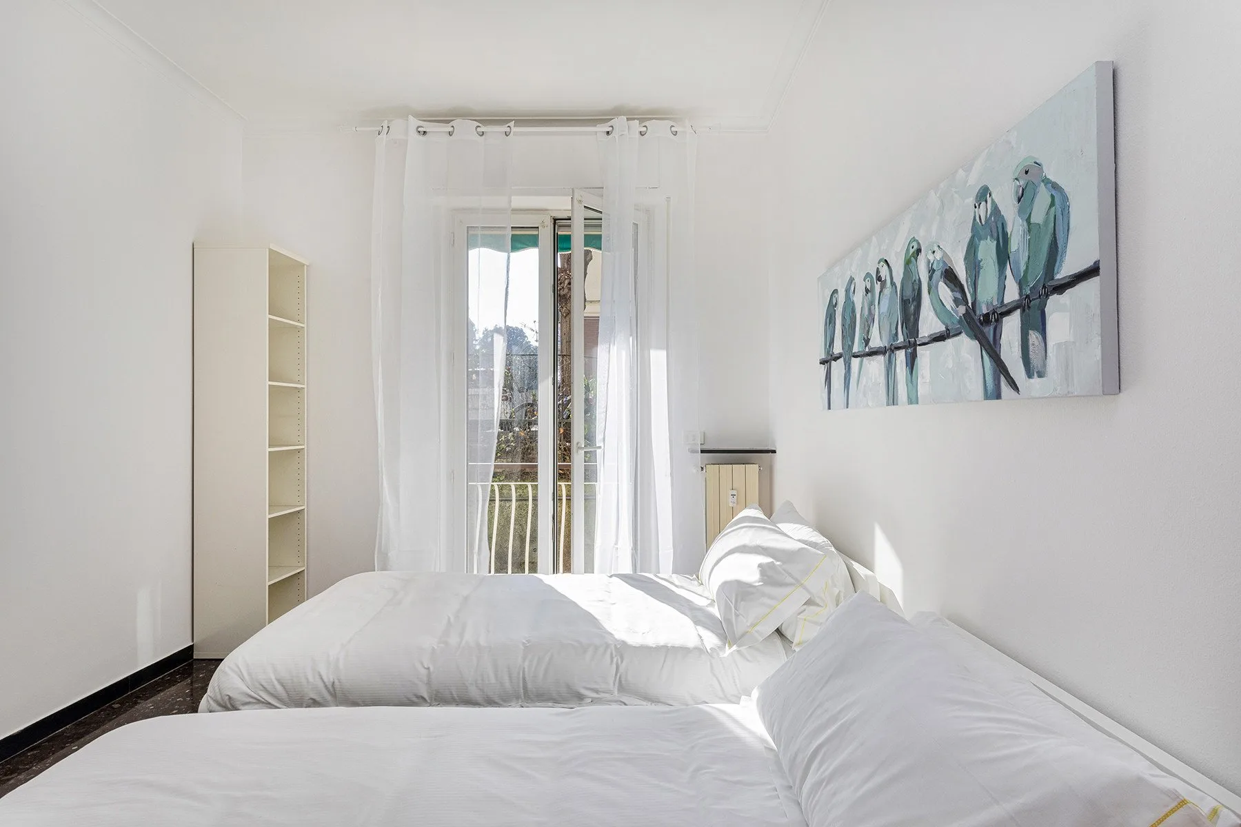 Un dormitorio luminoso con ropa de cama blanca y un cuadro grande de aves en la pared.