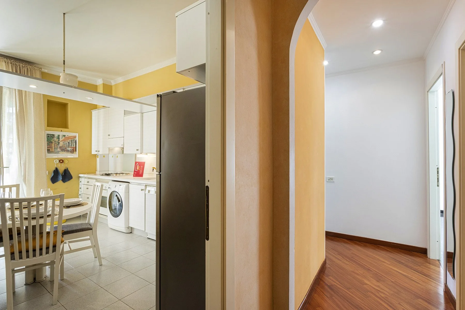 El comedor y la cocina dan a un pasillo con suelo de madera.