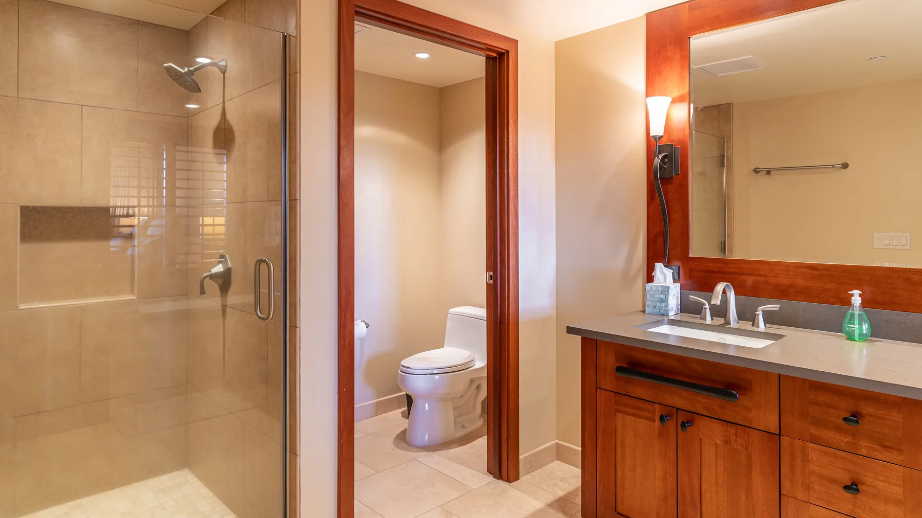 Un baño con ducha de vidrio, lavabo y espejo.
