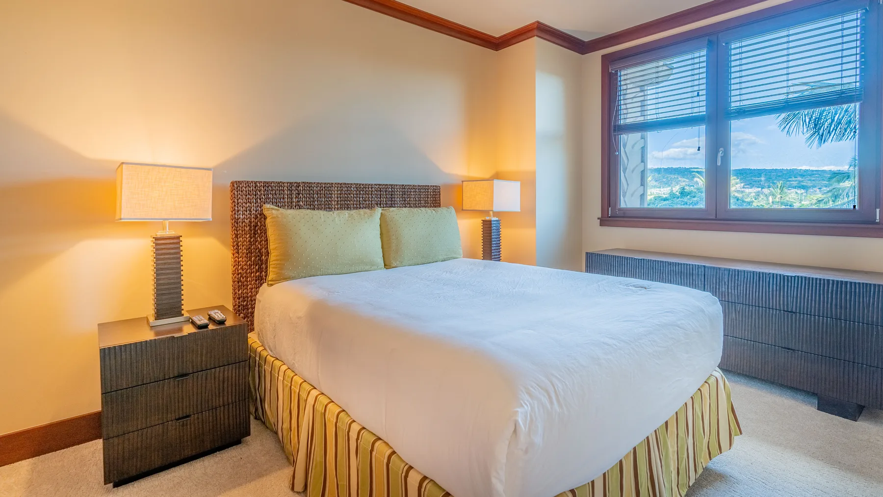 Un dormitorio con una cama bien hecha y una ventana grande.