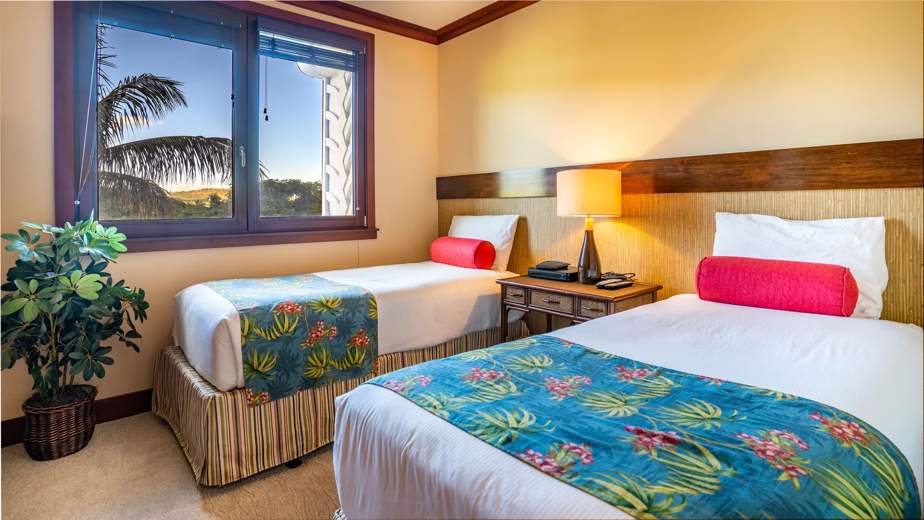 Un dormitorio con dos camas y una ventana con vista a palmeras.
