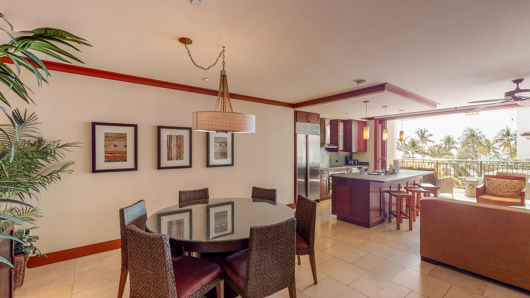 Un comedor y cocina de planta abierta con una mesa de vidrio y una isla de cocina.