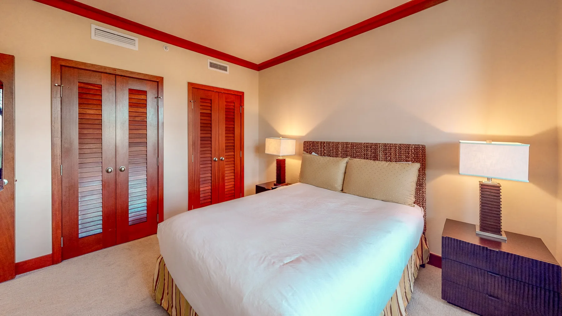 Un dormitorio con una cama grande, mesitas de noche y puertas de madera.