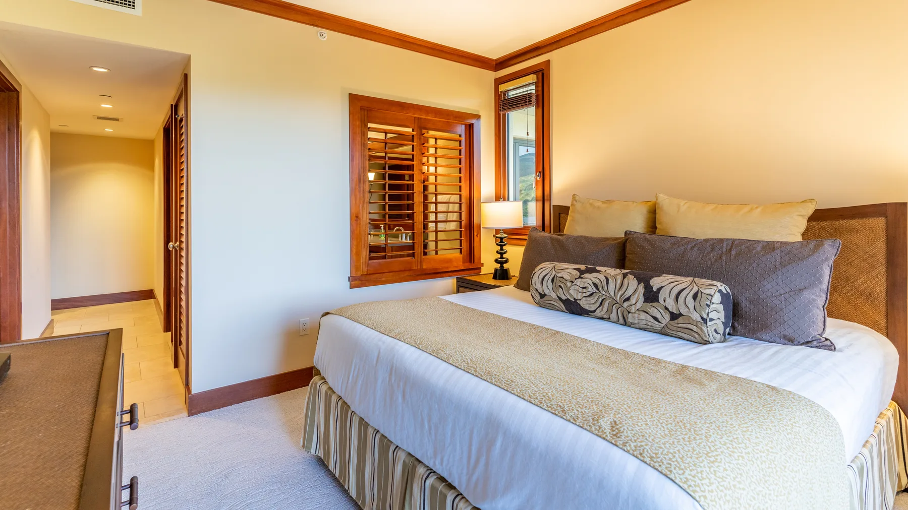 Un dormitorio con una cama grande y ventanas con marcos de madera.