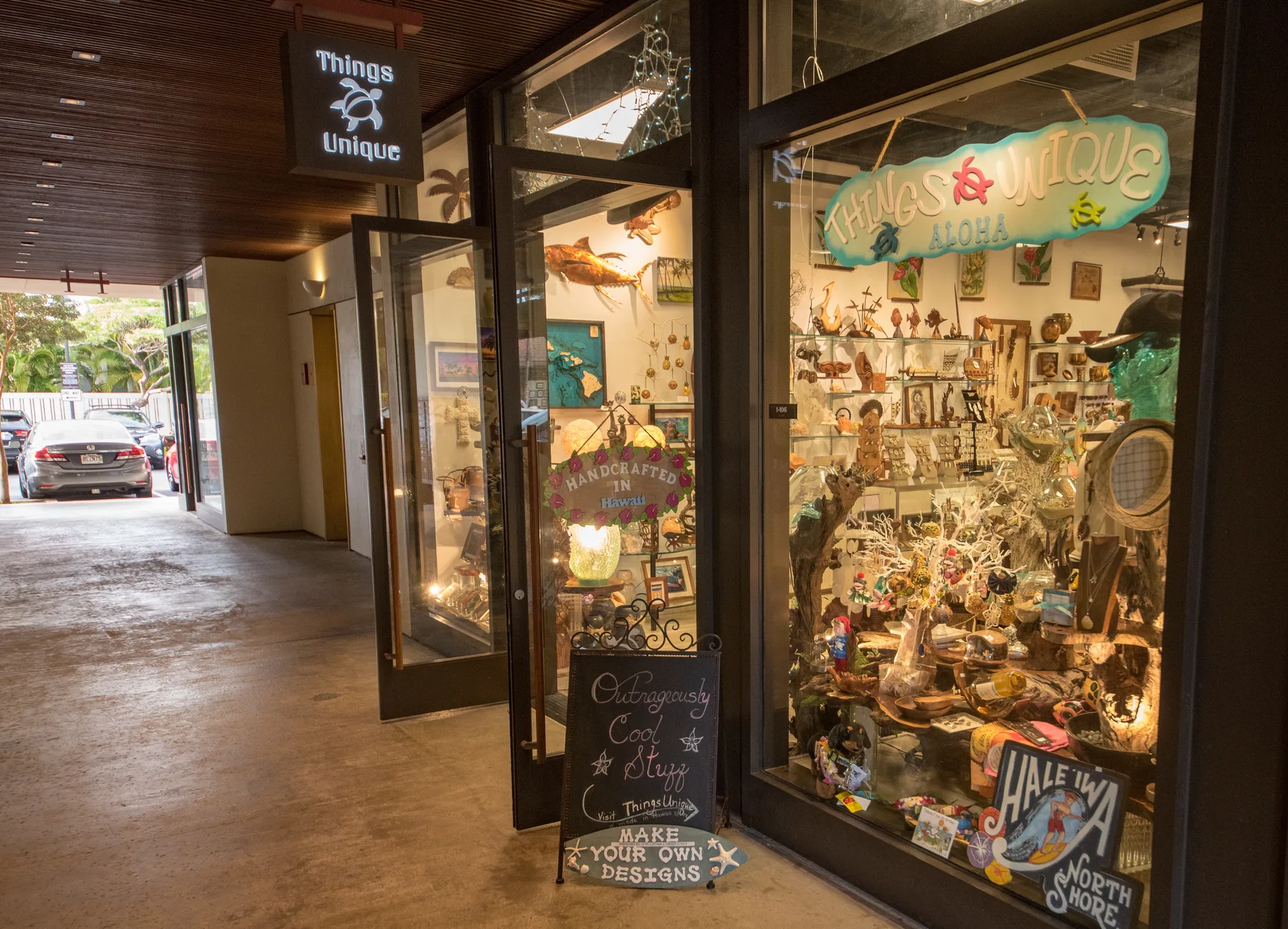 La entrada de una tienda deja ver un interior repleto de productos y letreros coloridos.